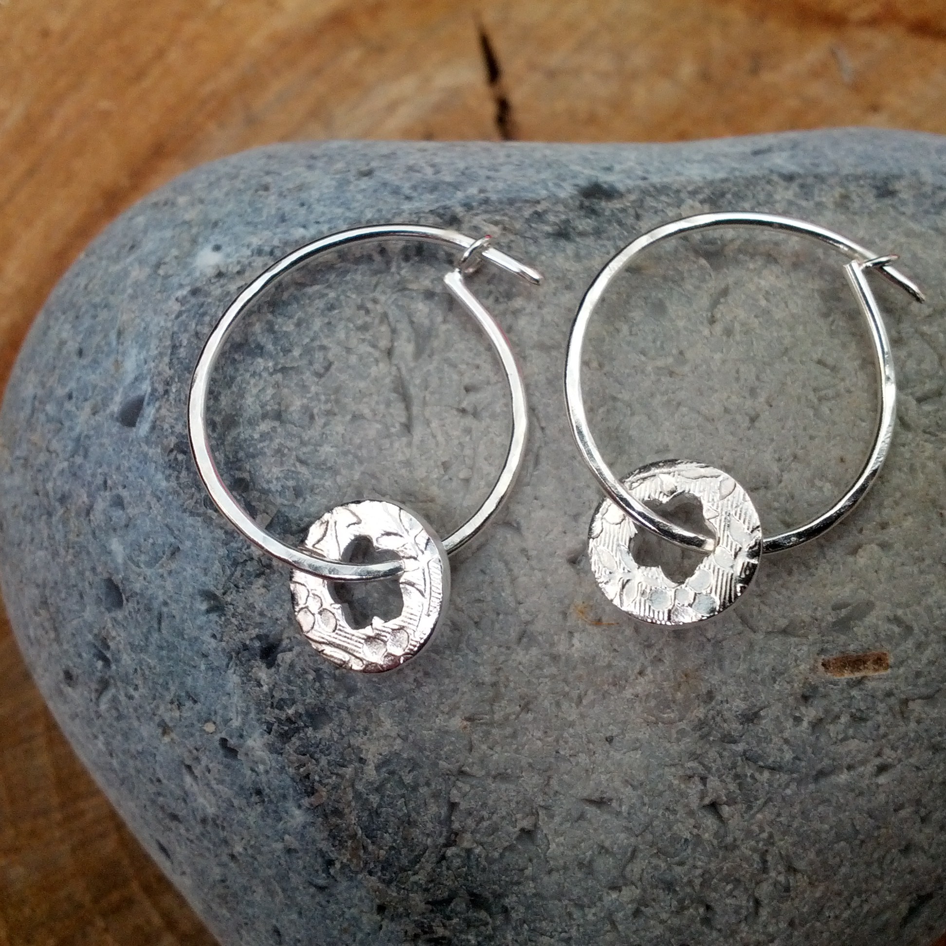 Silver hoop earrings with cut out flower dangles