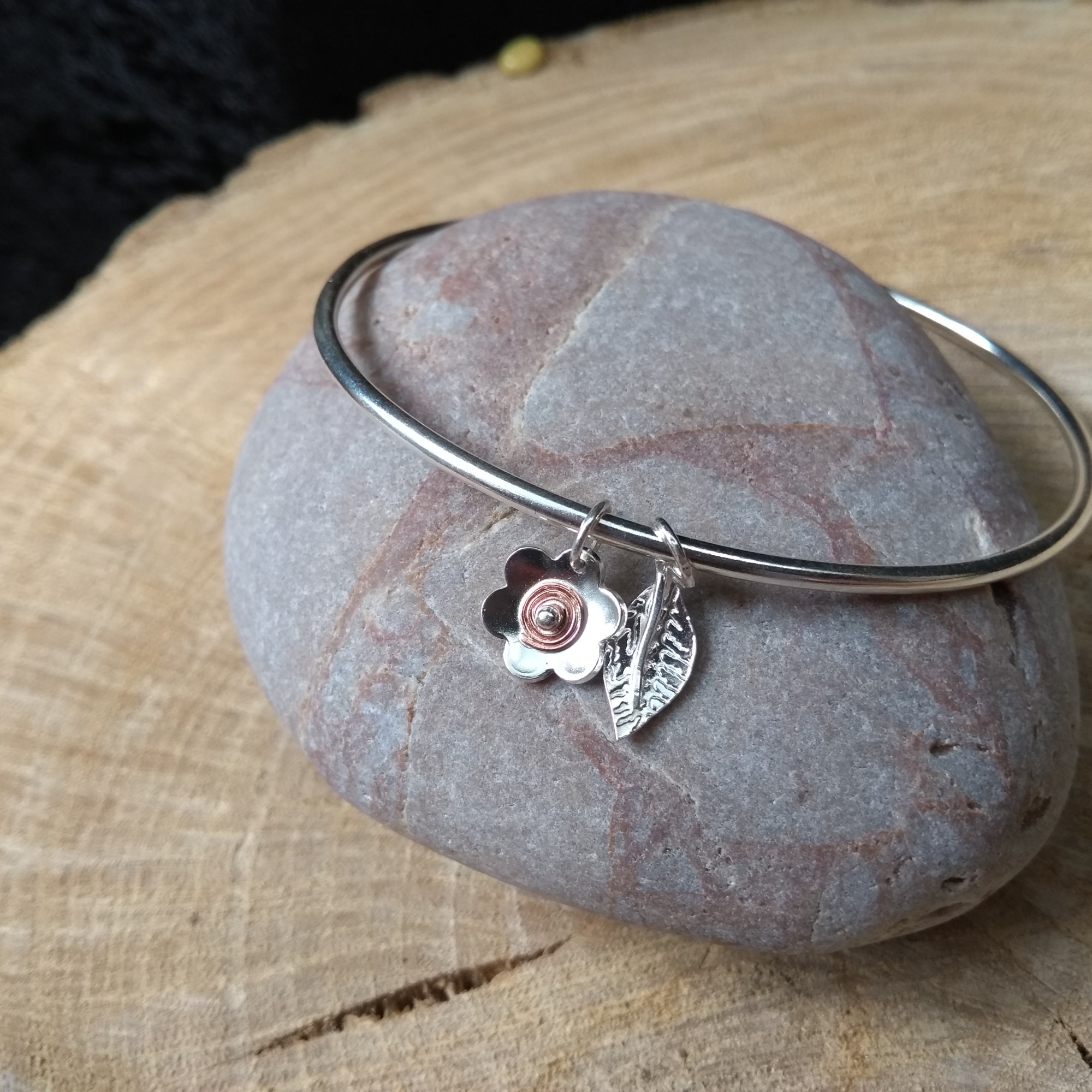 Silver bangle with silver and copper flower and leaf dangles